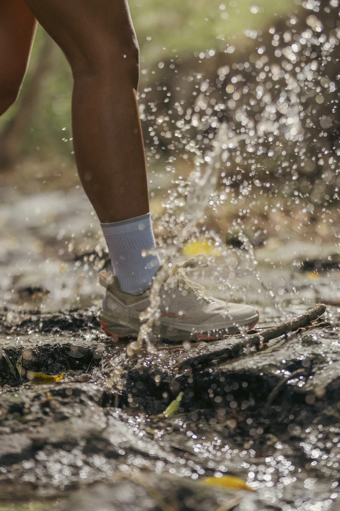 Tenis Altra de trail pisando un charco de barro